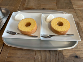 白い角皿に盛り付けられたバウムクーヘンと生クリーム