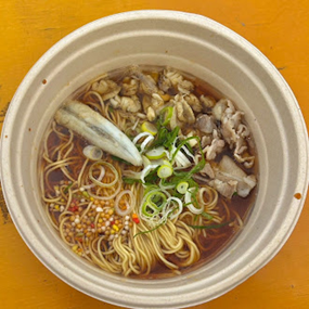 ネギや肉、薬味がトッピングされた温かいラーメン