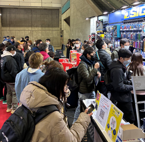 展示ブースの前で工具や展示物を熱心に見つめる大勢の来場者