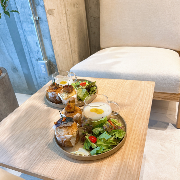 木製テーブルに置かれたスープ、サラダ、食事系マフィンのワンプレートランチ