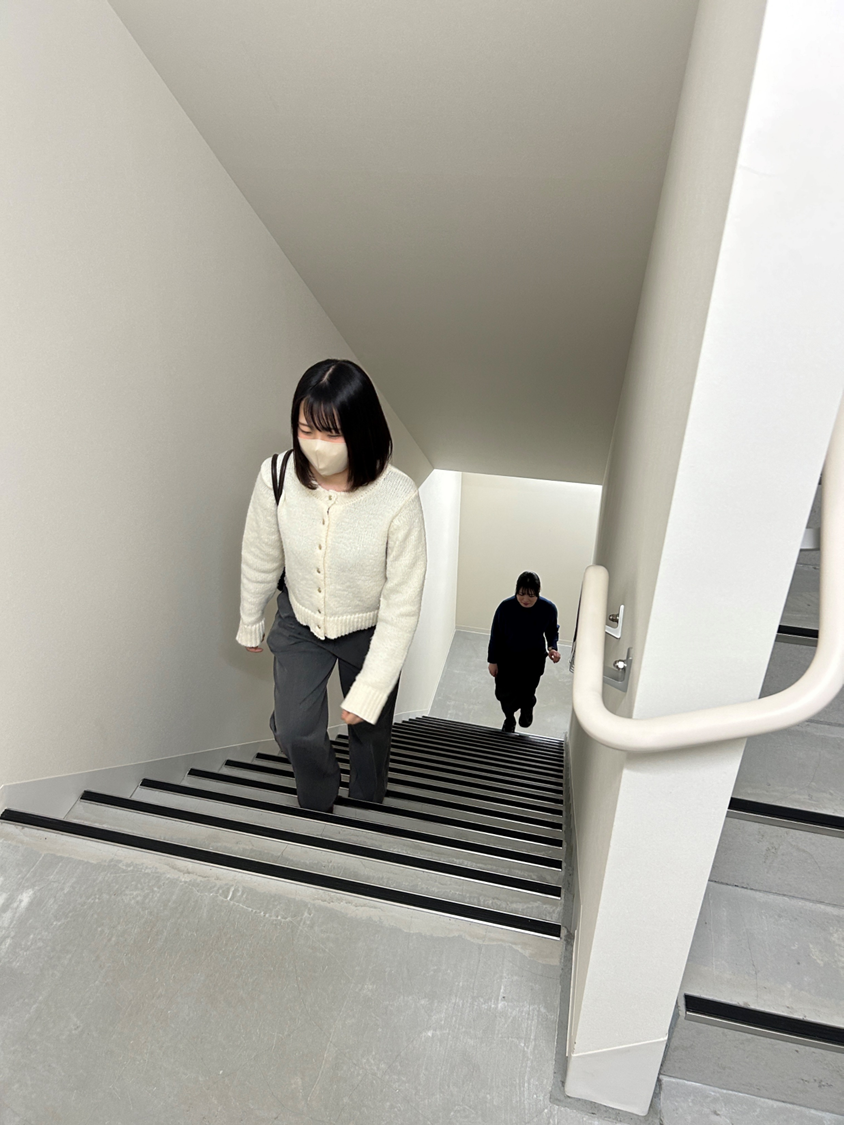 シンプルなデザインの階段を上っていく女性たち
