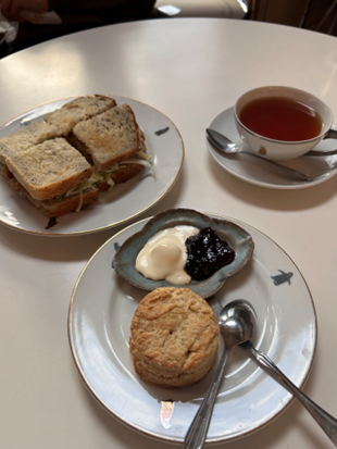 サンドイッチ、スコーン、ジャム、紅茶が並んだカフェのテーブル