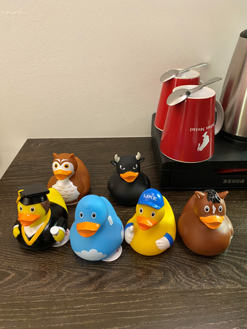 卓上に一列に並べられたさまざまなキャラクターデザインのアヒルのおもちゃ