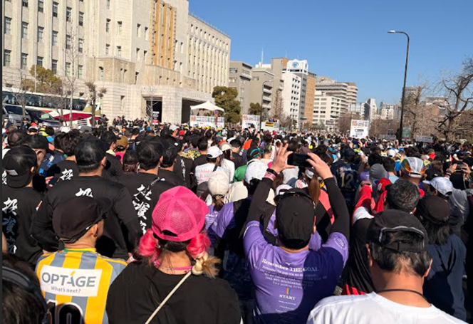 スタートラインの前で待機する大勢のマラソンランナーたち