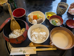 おひつご飯、とろろ、小鉢などが並ぶ和食の定食